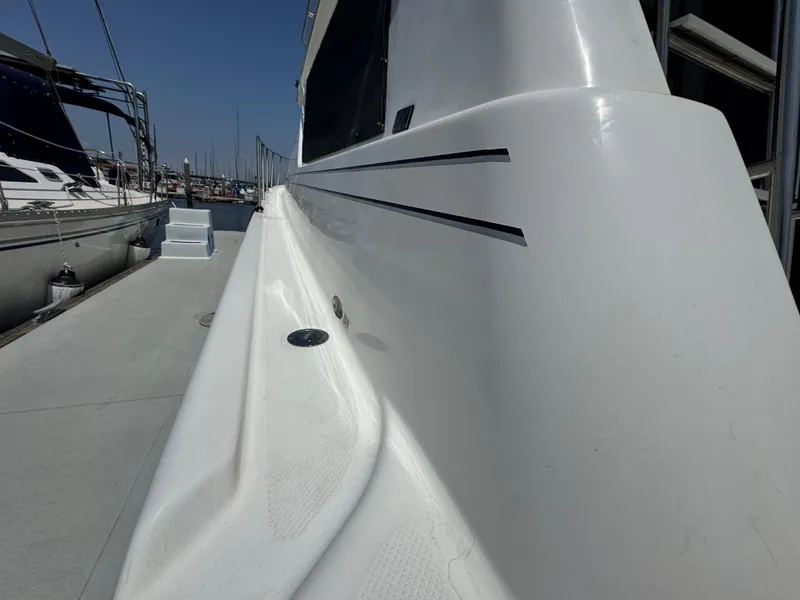 Slide: The Image of 2000 Bayliner 3988 yacht docked, showcasing sleek white exterior and modern design. - 20