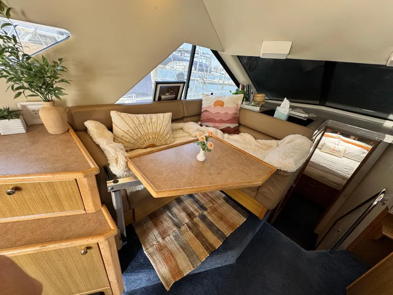 Slide: The Image of Interior of 2000 Bayliner 3988 yacht with cozy seating, table, and decorative pillows. - 27