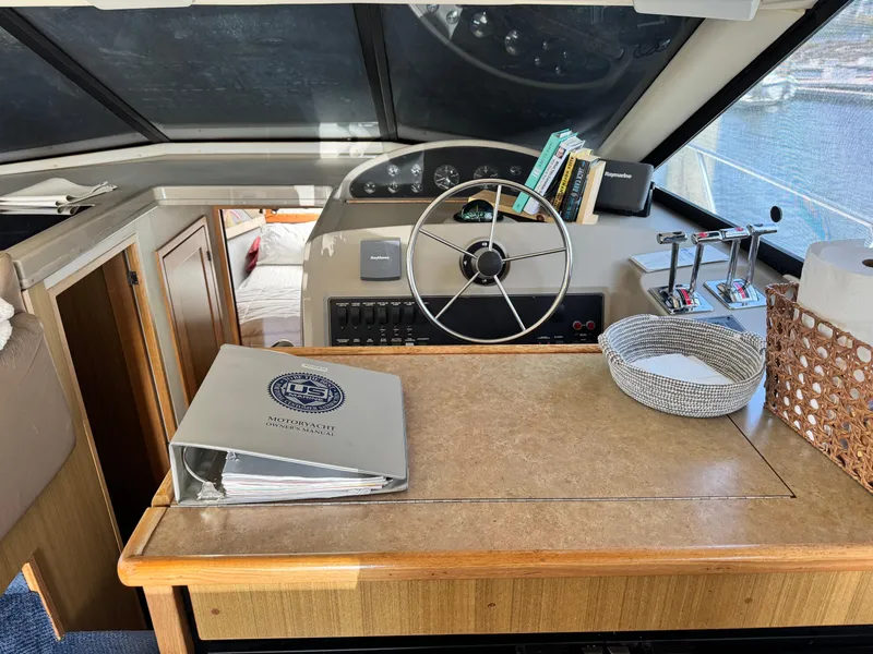 Slide: The Image of Interior of 2000 Bayliner 3988 yacht with steering wheel, books, and navigation equipment. - 29