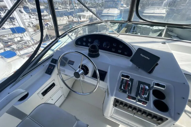 Slide: The Image of Cockpit of 2000 Bayliner 3988 yacht with steering wheel and navigation controls. - 3
