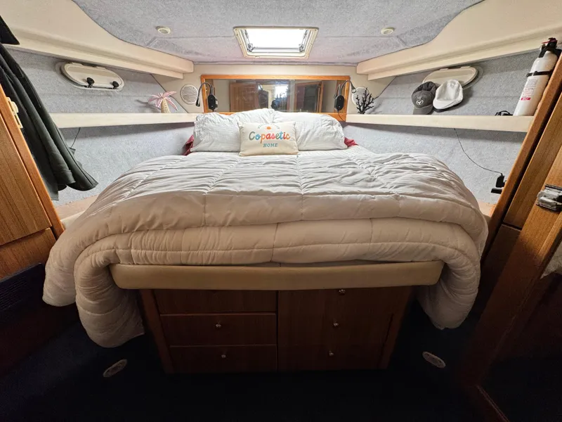 Slide: The Image of Cozy bedroom in 2000 Bayliner 3988 yacht with plush bedding and storage. - 36