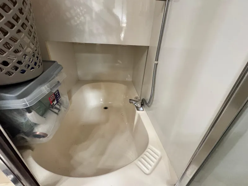 Slide: The Image of 2000 Bayliner 3988 bathroom with shower, storage basket, and plastic container. - 38