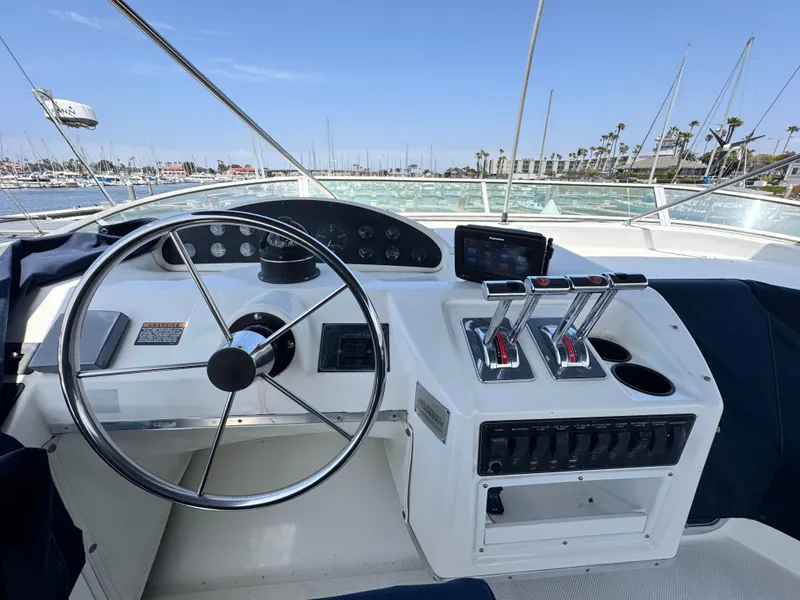 Slide: The Image of Cockpit of 2000 Bayliner 3988 yacht with steering wheel and control panel, docked at marina. - 46