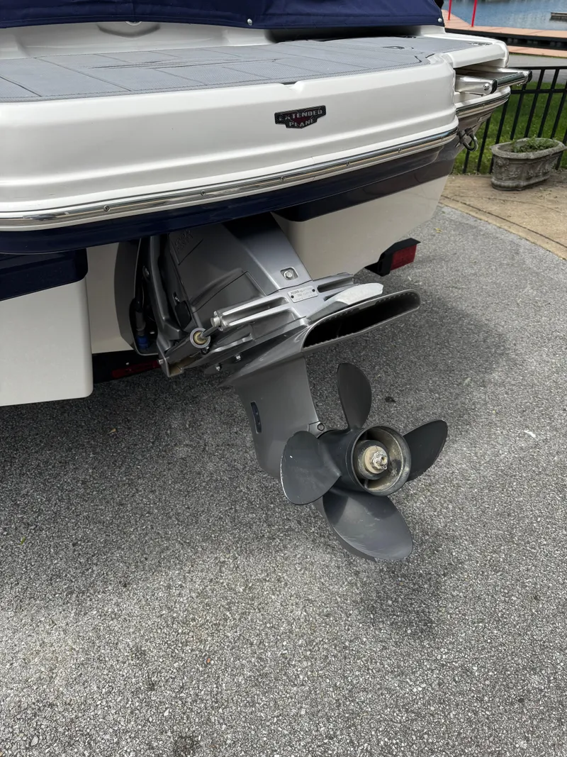 Slide: The Image of 2022 Chaparral 21 SSi boat stern with propeller, parked on pavement. - 4
