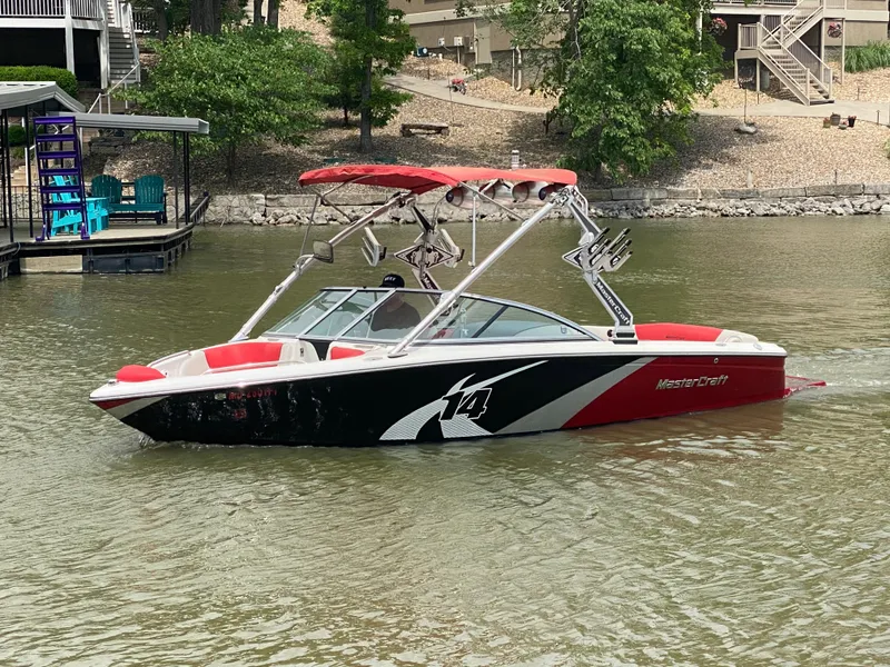 Slide: The Image of 2011 MasterCraft X14 boat with red and black design on a lake. - 14