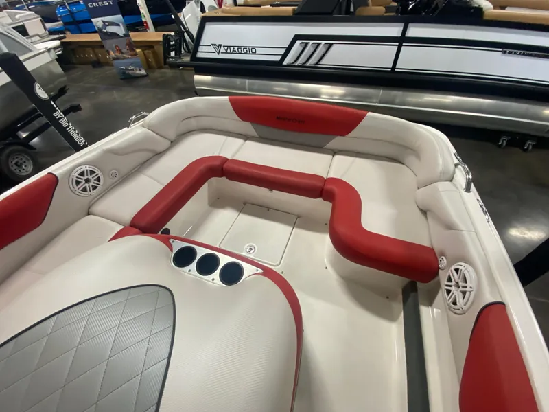 Slide: The Image of 2011 MasterCraft X14 boat interior with red and white seating, cup holders, and speakers. - 22