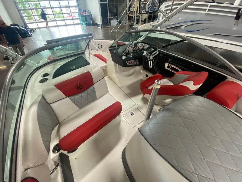Slide: The Image of 2011 MasterCraft X14 boat interior with red and gray seating, modern dashboard, and spacious layout. - 23