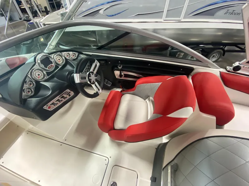 Slide: The Image of 2011 MasterCraft X14 boat interior with red and white seating, modern dashboard, and steering wheel. - 27