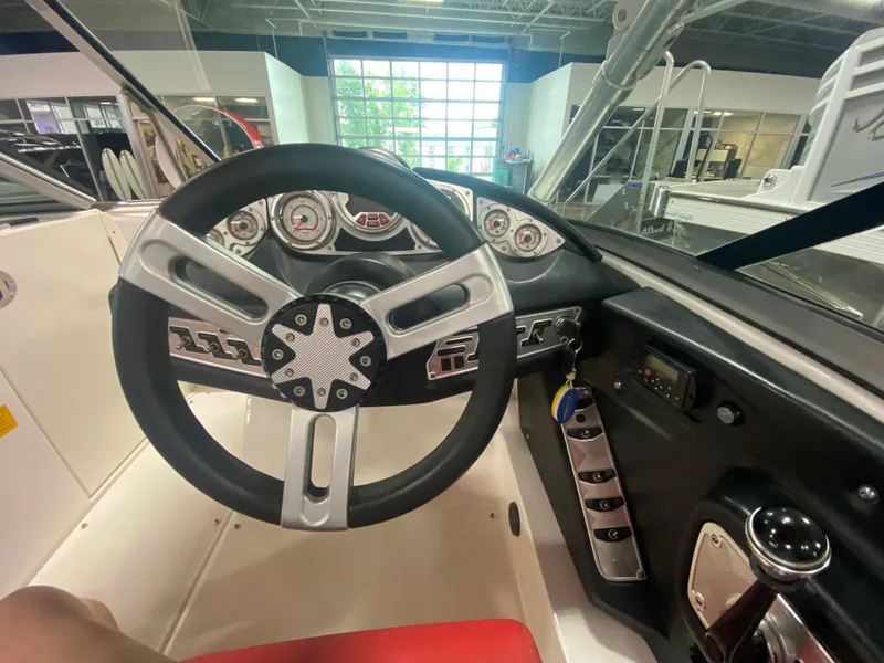 Slide: The Image of Interior view of 2011 MasterCraft X14 boat dashboard with steering wheel and controls. - 28