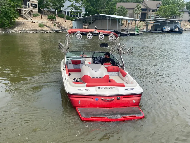 Slide: The Image of 2011 MasterCraft X14 boat on a lake, featuring red and white design. - 8