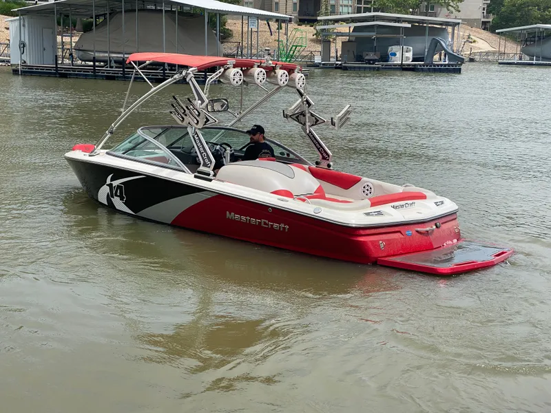 Slide: The Image of 2011 MasterCraft X14 boat in red and white on a calm lake. - 9