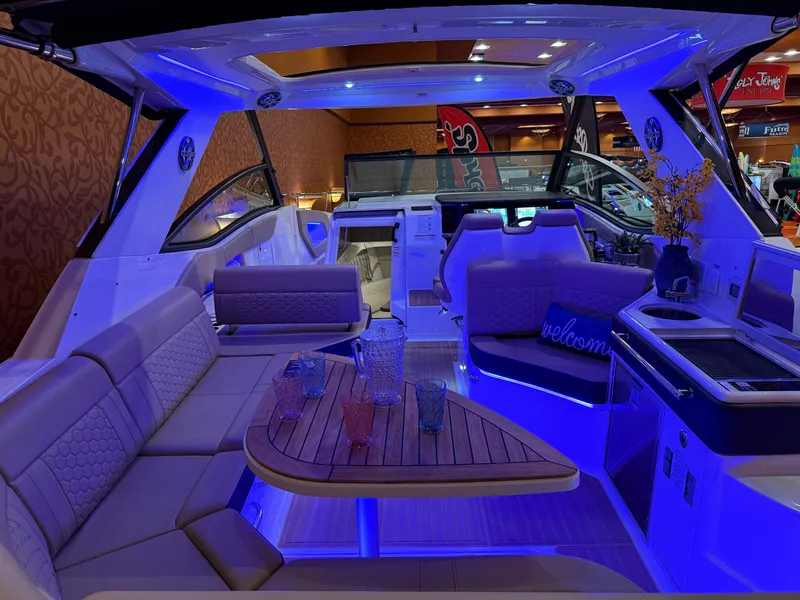 Slide: The Image of Luxurious 2024 Sea Ray Sundancer 320 interior with ambient blue lighting and elegant seating. - 6