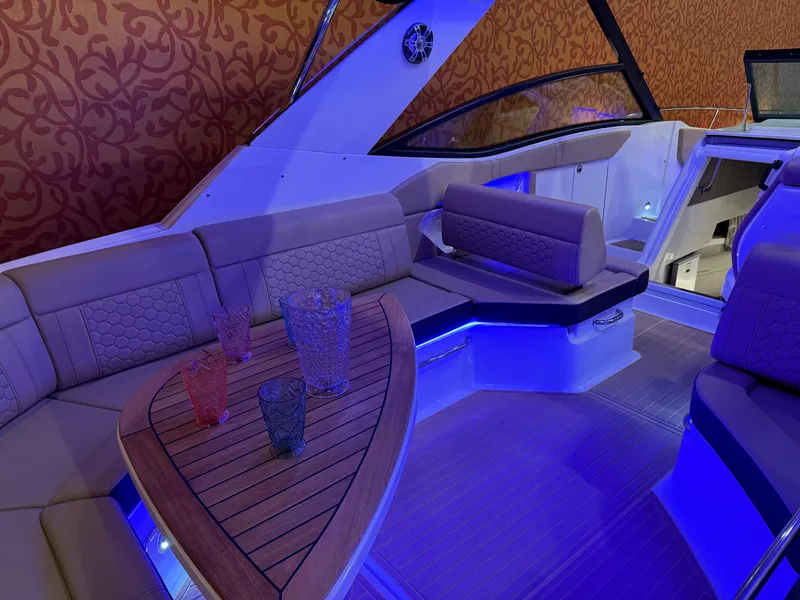 Slide: The Image of Luxurious 2024 Sea Ray Sundancer 320 interior with ambient blue lighting and elegant seating. - 9