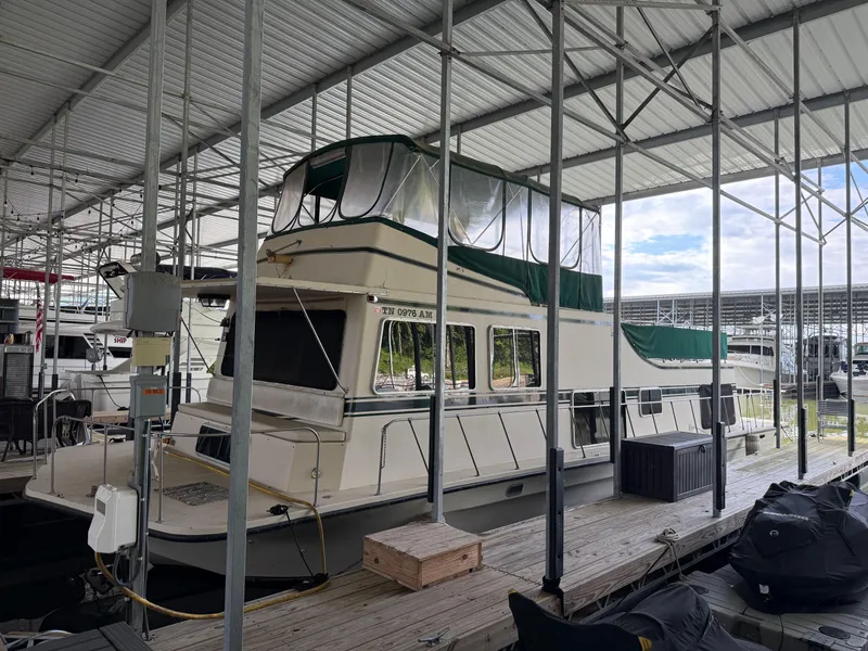 Slide: The Image of 1980 Harbor Master 47 houseboat docked in a covered marina. - 1
