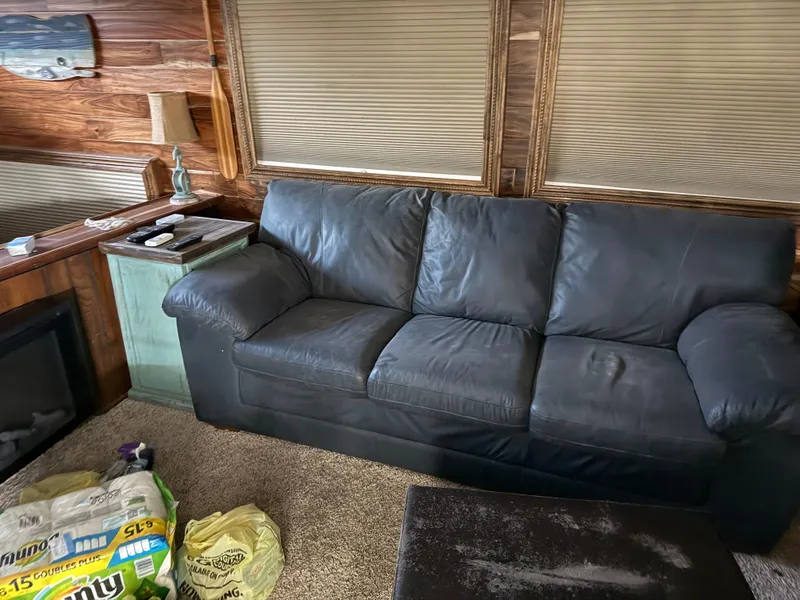 Slide: The Image of Black leather sofa in a cozy 1980 Harbor Master 47 interior with wood paneling. - 12