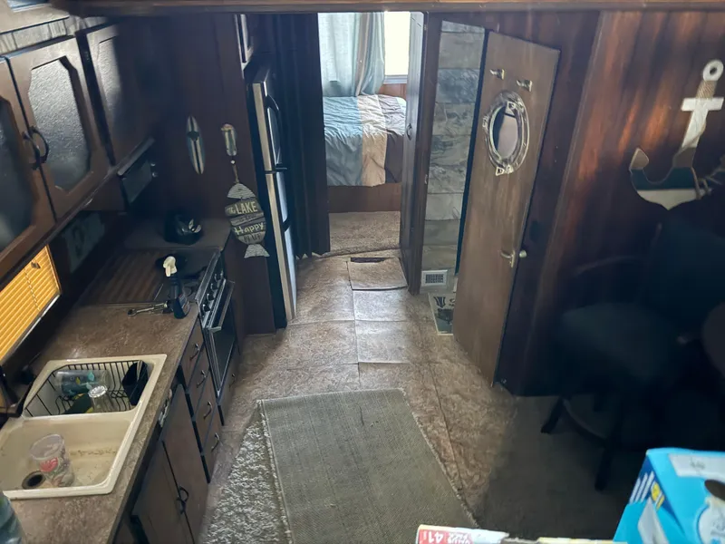 Slide: The Image of Interior of a 1980 Harbor Master 47 boat, featuring a cozy kitchen and living area. - 14