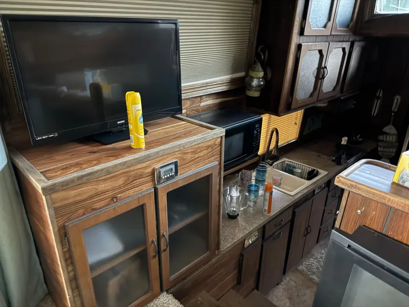 Slide: The Image of 1980 Harbor Master 47 interior with TV, wooden cabinets, and kitchen sink. - 16