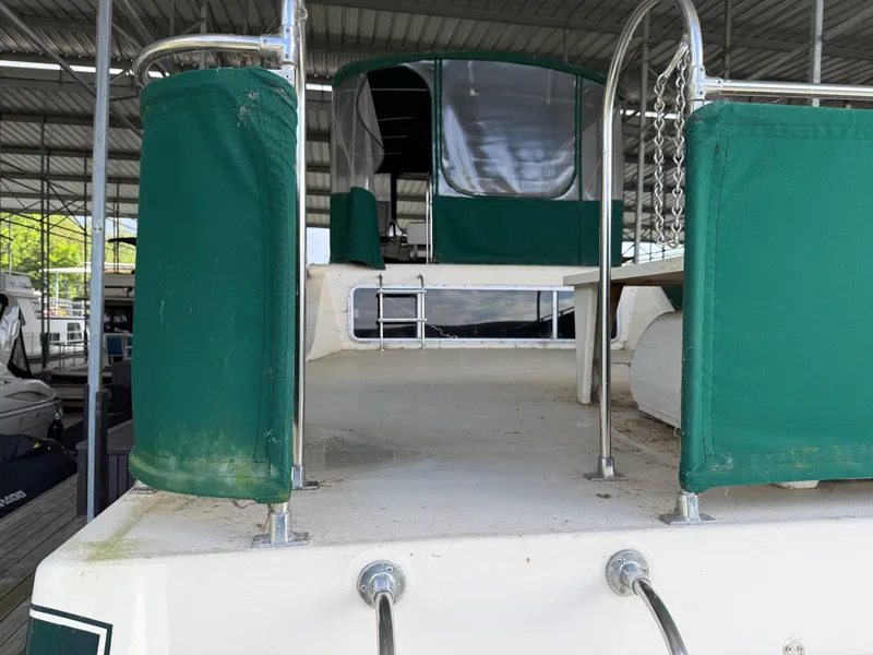 Slide: The Image of 1980 Harbor Master 47 boat deck with green canvas covers in a marina. - 18