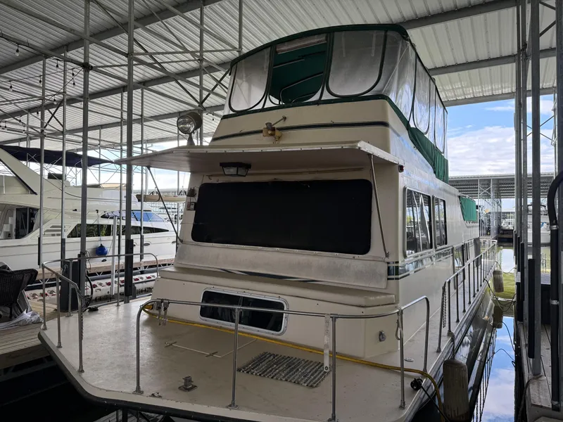 Slide: The Image of 1980 Harbor Master 47 houseboat docked in a covered marina. - 2