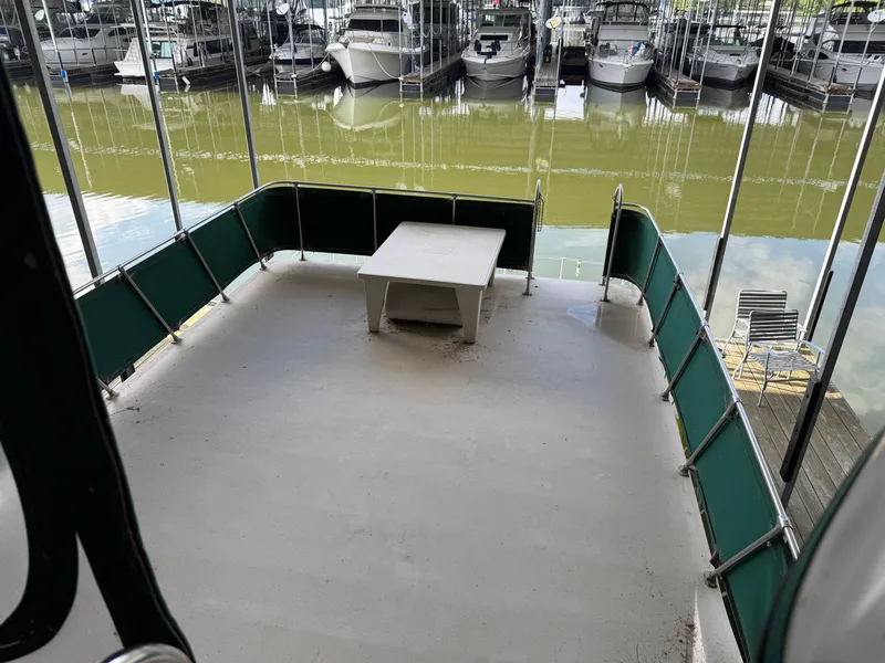 Slide: The Image of 1980 Harbor Master 47 boat deck with green railing, table, and marina view. - 22