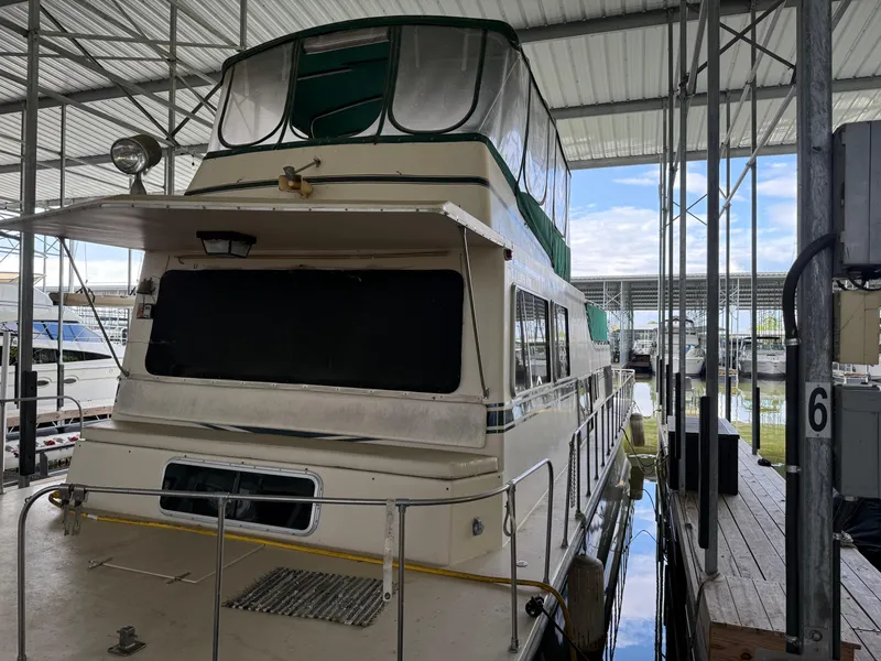 Slide: The Image of 1980 Harbor Master 47 houseboat docked in a covered marina. - 3