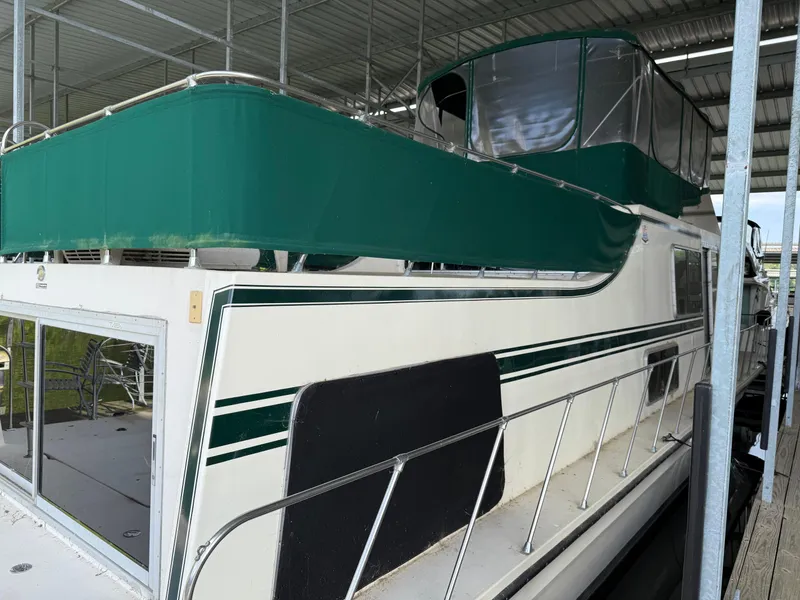 Slide: The Image of 1980 Harbor Master 47 yacht with green canopy, docked under a covered marina. - 8