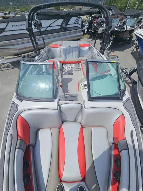 Slide: The Image of 2023 Sanger V237 SX boat with red and gray interior, docked among other boats. - 12