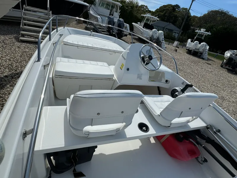 Slide: The Image of 2016 Boston Whaler 150 Super Sport boat with white seating and steering console. - 2