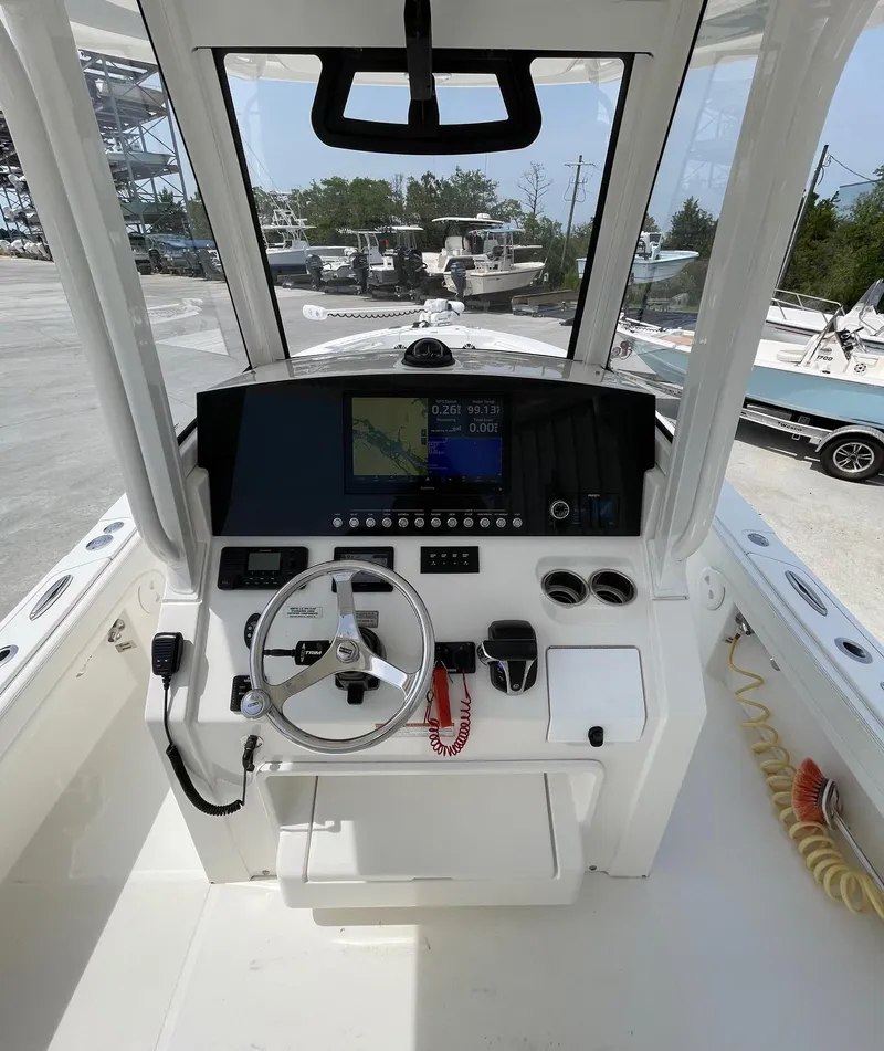 Slide: The Image of 2021 Regulator 26XO boat cockpit with steering wheel and navigation display. - 12