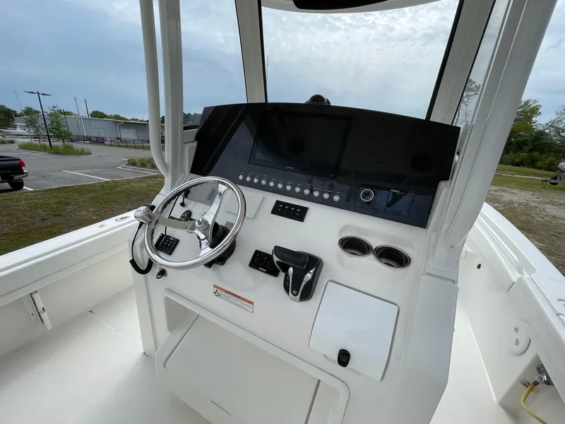 Slide: The Image of 2021 Regulator 26XO boat console with steering wheel and control panel. - 13