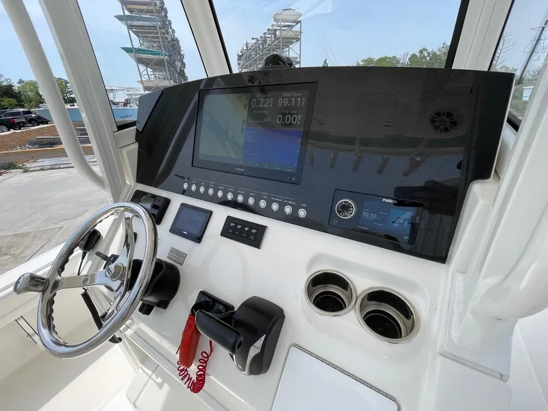 Slide: The Image of 2021 Regulator 26XO boat dashboard with steering wheel and electronic controls. - 14