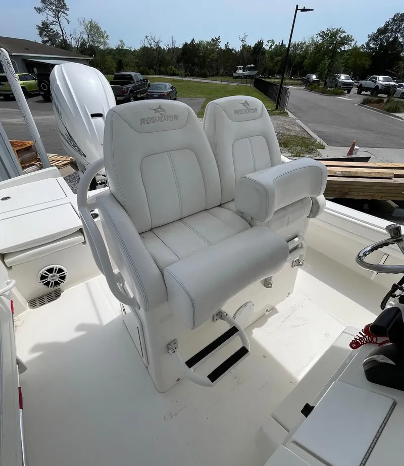Slide: The Image of 2021 Regulator 26XO boat with dual white captain's chairs and sleek interior design. - 18