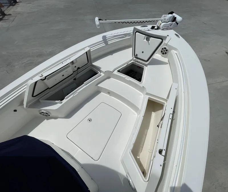 Slide: The Image of 2021 Regulator 26XO boat deck with open storage compartments and trolling motor. - 27