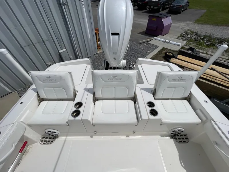 Slide: The Image of 2021 Regulator 26XO boat with three white cushioned seats and cup holders. - 31