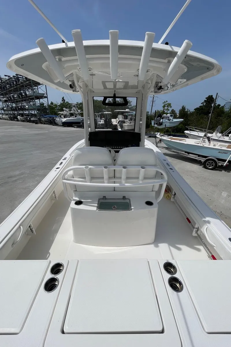 Slide: The Image of 2021 Regulator 26XO boat with spacious deck and seating, docked outdoors. - 32
