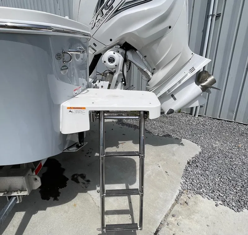 Slide: The Image of 2021 Regulator 26XO boat with ladder and outboard motor, parked on concrete. - 35