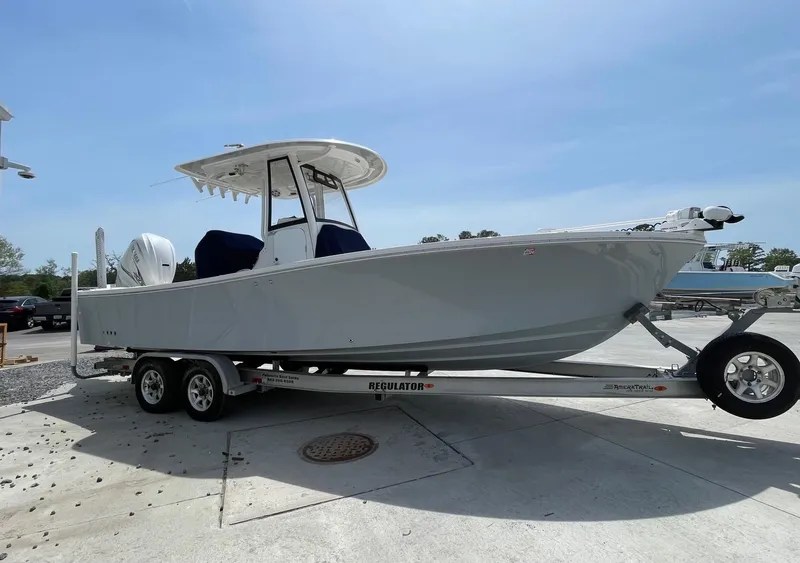 Slide: The Image of 2021 Regulator 26XO boat on trailer, parked outdoors under clear sky. - 4