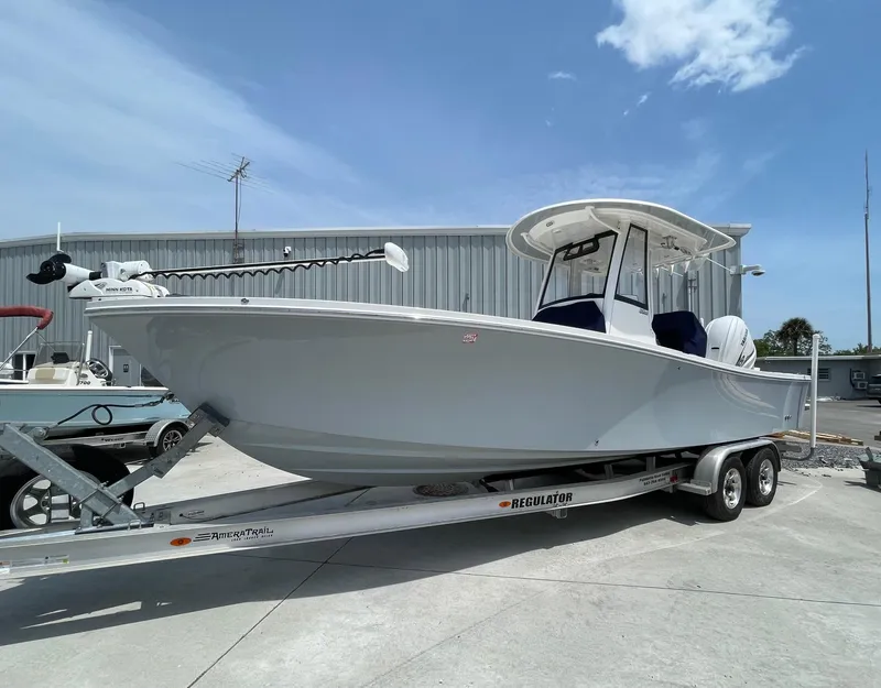 Slide: The Image of 2021 Regulator 26XO boat on trailer, parked outdoors under clear sky. - 5