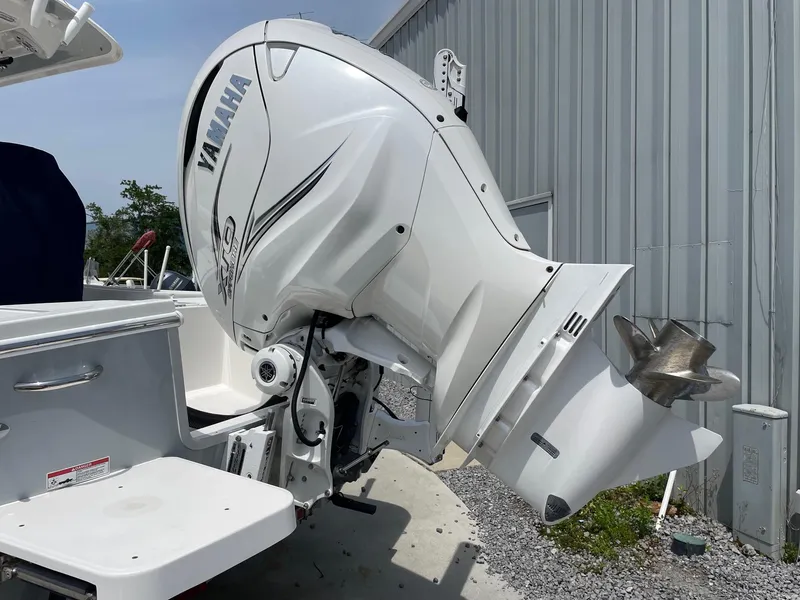 Slide: The Image of 2021 Regulator 26XO boat with Yamaha outboard motor, parked near a metal building. - 7