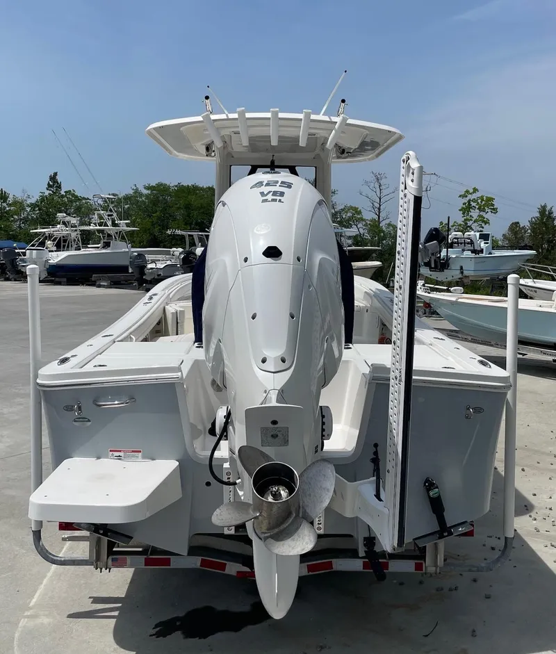 Slide: The Image of 2021 Regulator 26XO boat, rear view, on a trailer in a marina setting. - 8