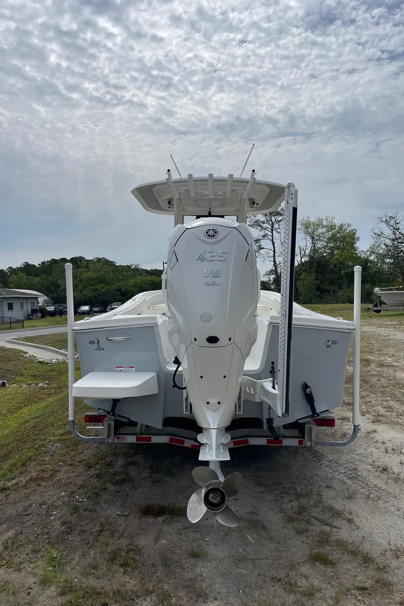 Slide: The Image of 2021 Regulator 26XO boat on trailer, rear view under cloudy sky. - 9