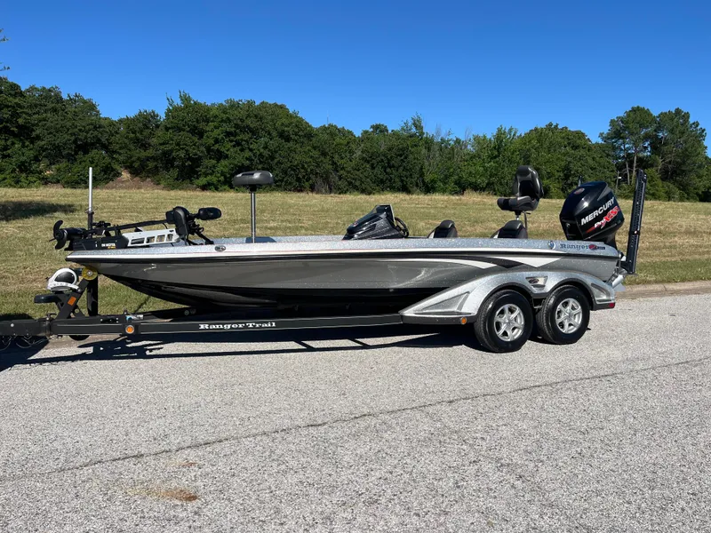 Slide: The Image of 2016 Ranger Z520 bass boat on trailer, parked on road with trees in background. - 36