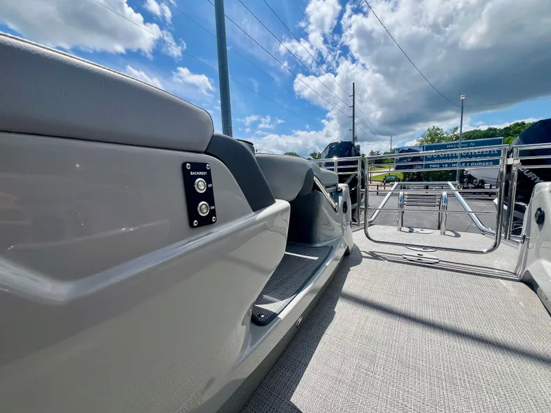 Slide: The Image of 2022 Manitou 25 LX SHP DE pontoon boat deck under a bright blue sky. - 19