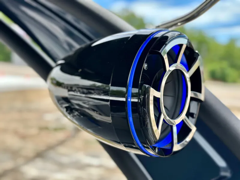 Slide: The Image of Close-up of a 2022 Manitou 25 LX SHP DE boat speaker with blue accents. - 22