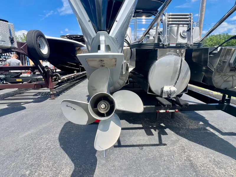 Slide: The Image of Propeller of 2022 Manitou 25 LX SHP DE boat on trailer, sunny day. - 25