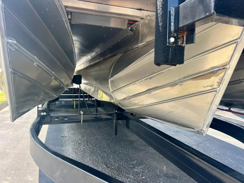 Slide: The Image of 2022 Manitou 25 LX SHP DE pontoon boat underside on trailer. - 31