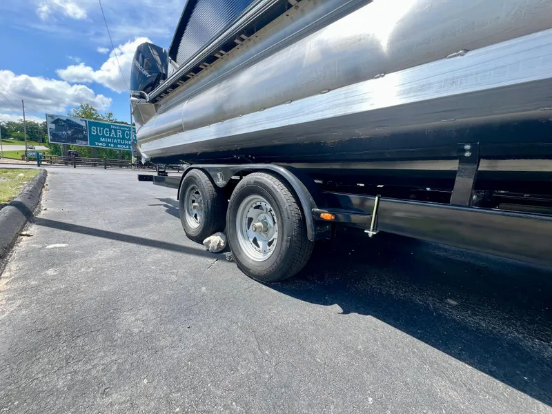 Slide: The Image of 2022 Manitou 25 LX SHP DE boat on trailer, parked on sunny day. - 34