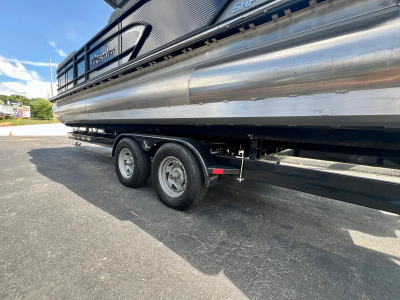 Slide: The Image of 2022 Manitou 25 LX SHP DE pontoon boat on a trailer, side view. - 35