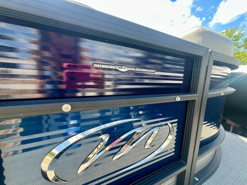 Slide: The Image of 2022 Manitou 25 LX SHP DE pontoon boat, close-up of sleek blue exterior design. - 4