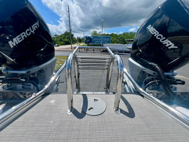 Slide: The Image of 2022 Manitou 25 LX SHP DE boat with dual Mercury engines and stainless steel ladder. - 6